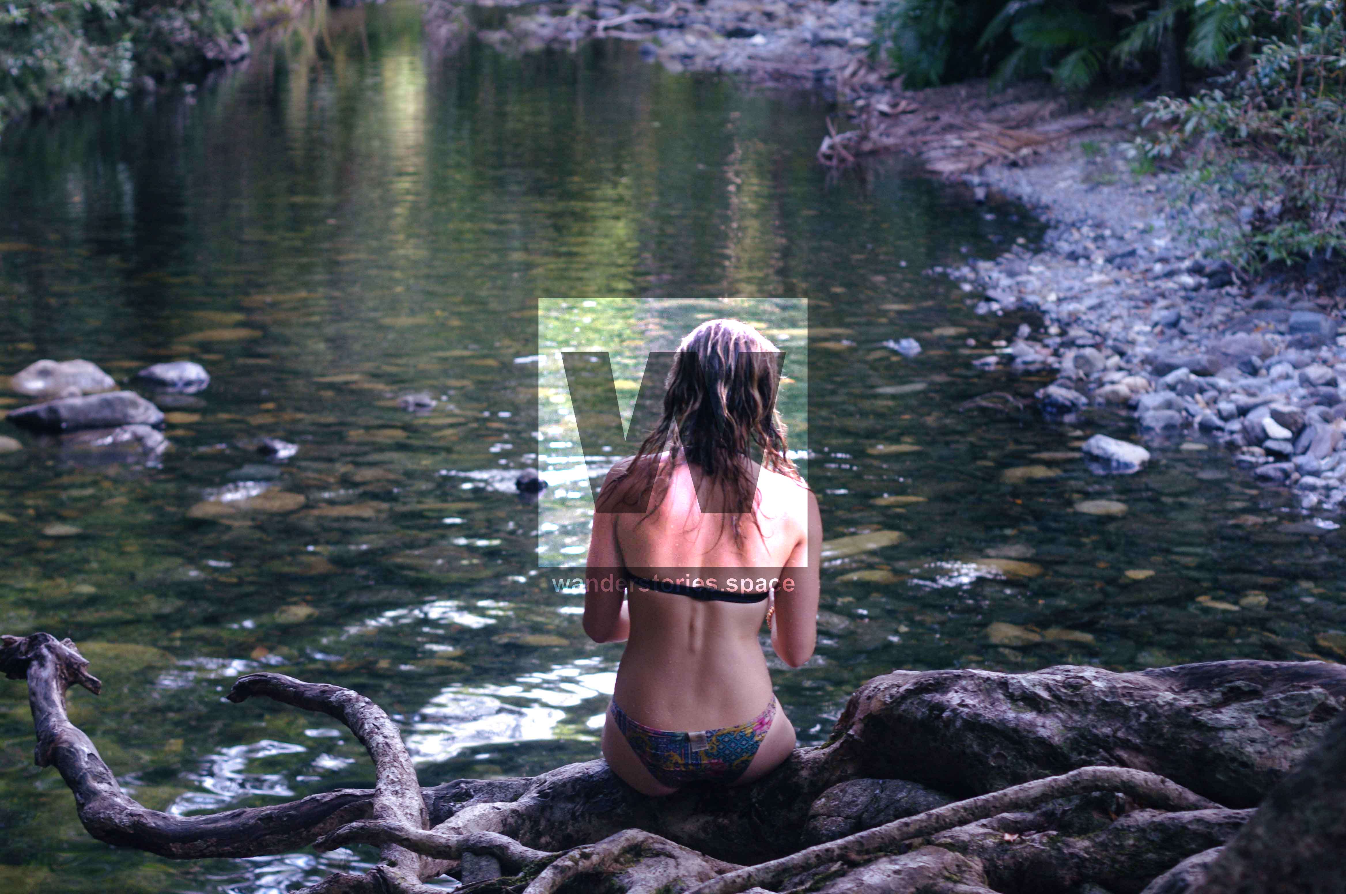 Sitting by a creek in a bikini